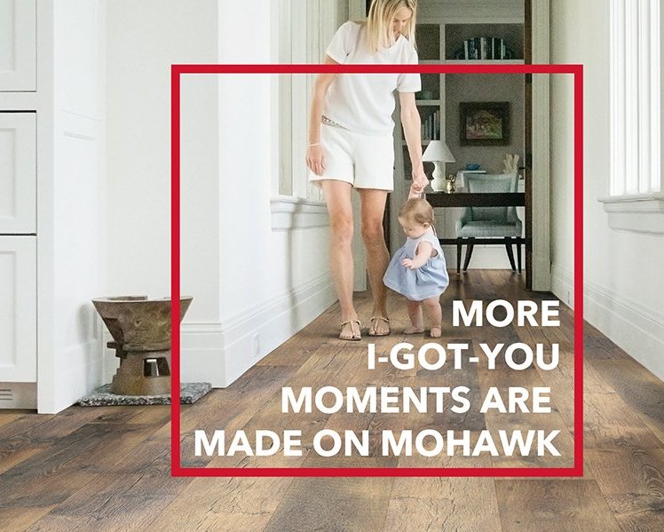 Mother hand holding walking baby on laminate flooring